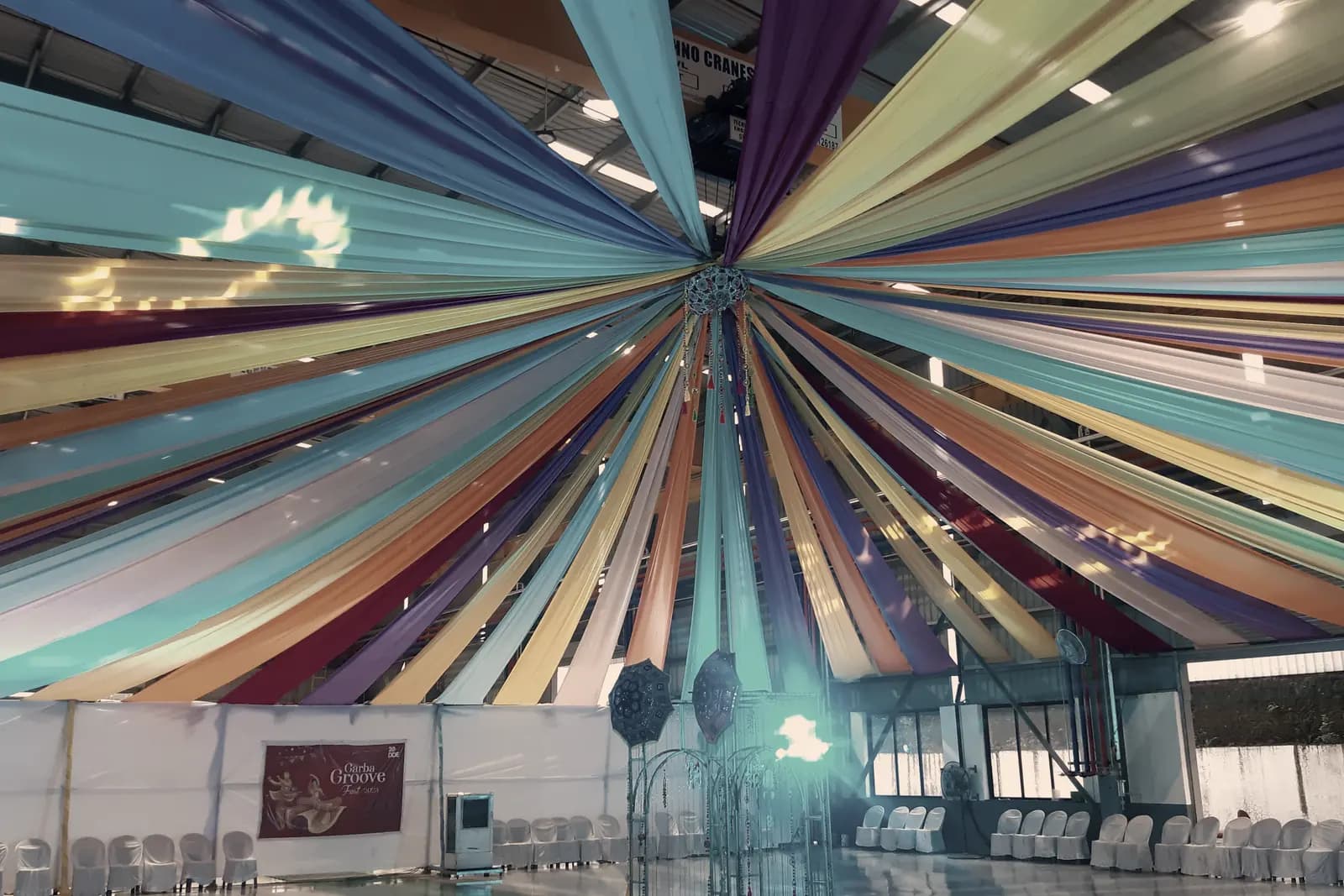 Looking up into a marquee ceiling of fabric panels radiating from a single point overhead.