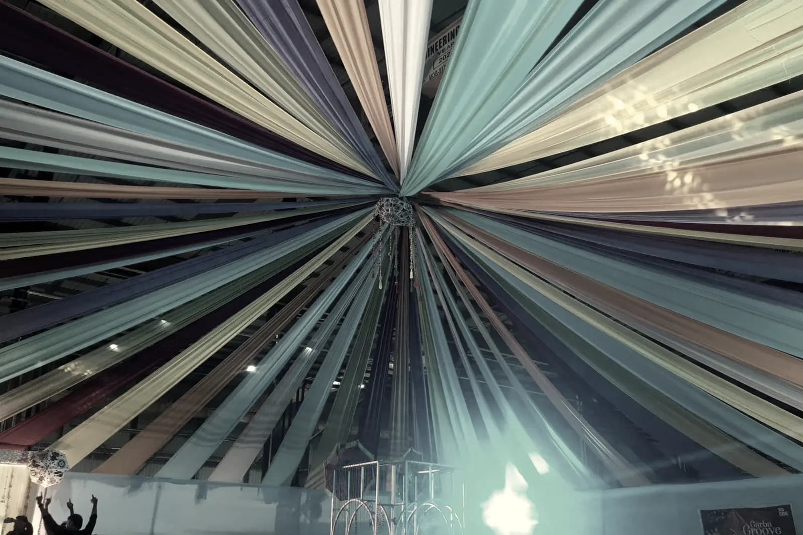 A second draped ceiling in cooler tones, panels converging above an empty floor.